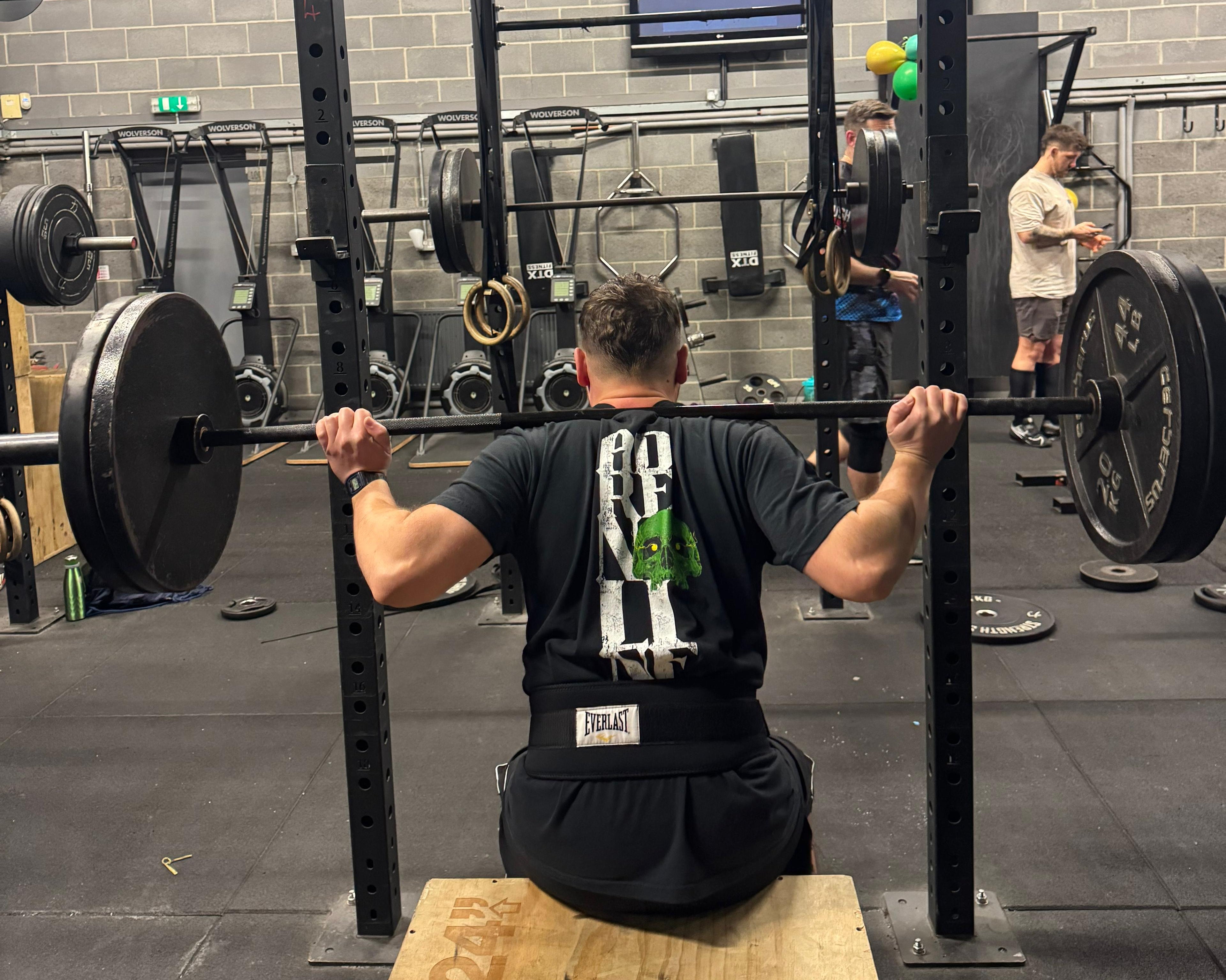 Person performing a barbell exercise in a gym setting